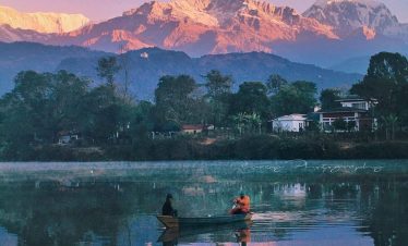 Boating on Phewa Lake with the World Peace Pagoda and mountains in the background