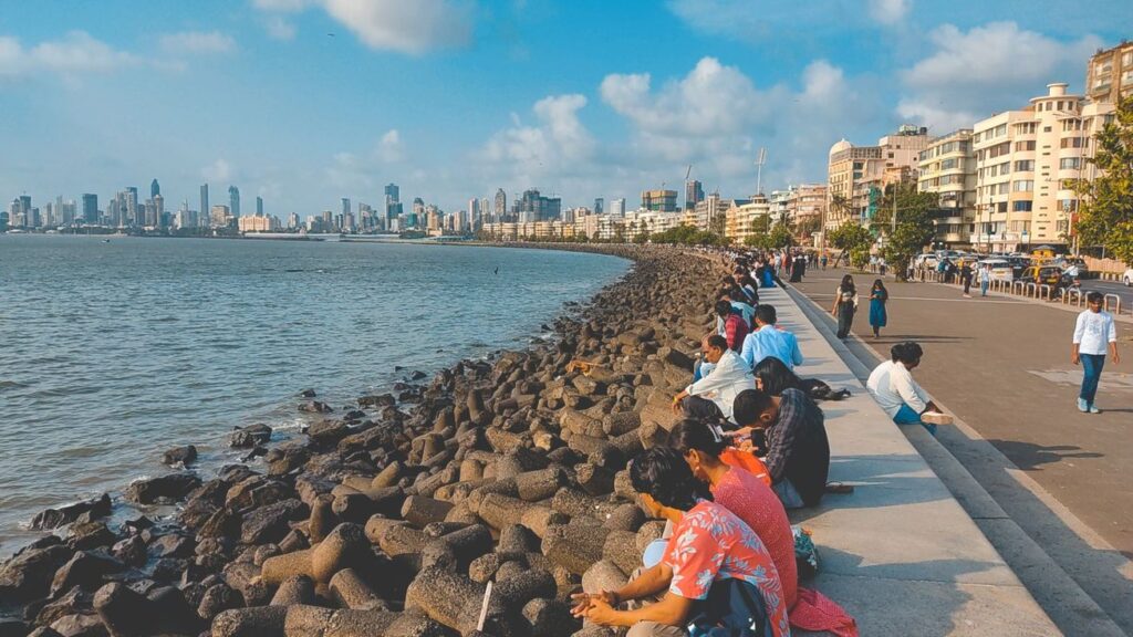 Marine Drive coastline with the Arabian Sea and city skyline under clear daytime skies in Mumbai