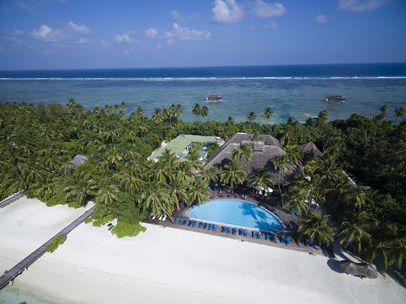 Aerial view of a tropical Maldivian island with white sandy beaches and lush greenery