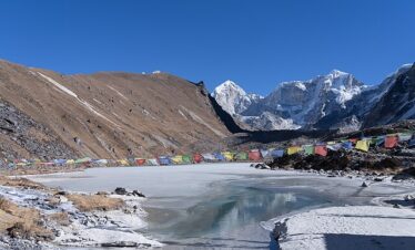 Frozen Dudhkunda Lake covered in ice with surrounding snow-capped mountains in Dolakha, Nepal