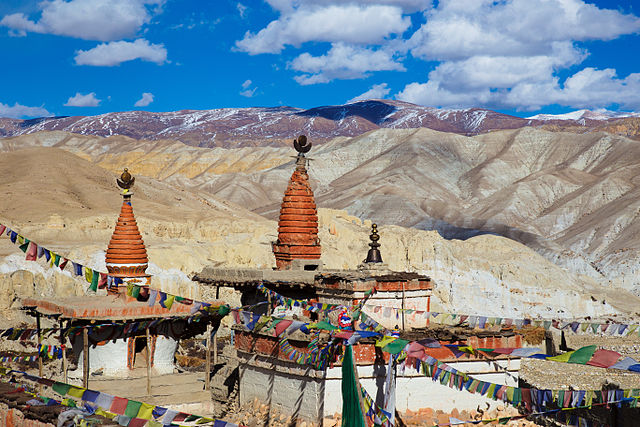Barren cliffs and ancient caves of Upper Mustang under clear blue sky