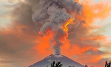 Sunset sky with glowing red volcanic smoke rising from Mount Agung in Bali