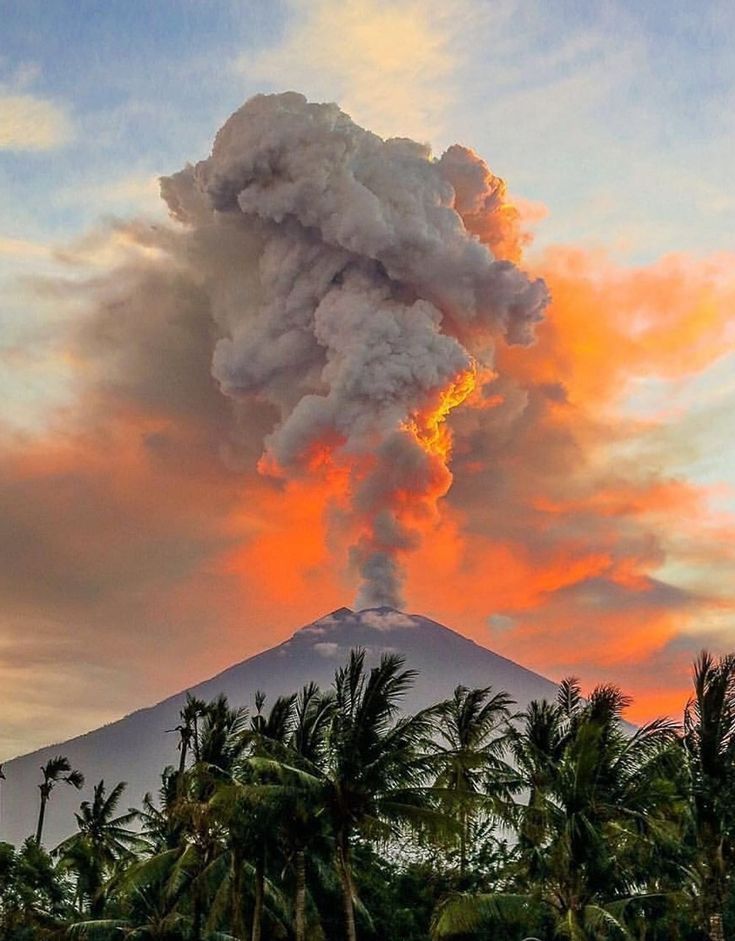 Sunset sky with glowing red volcanic smoke rising from Mount Agung in Bali