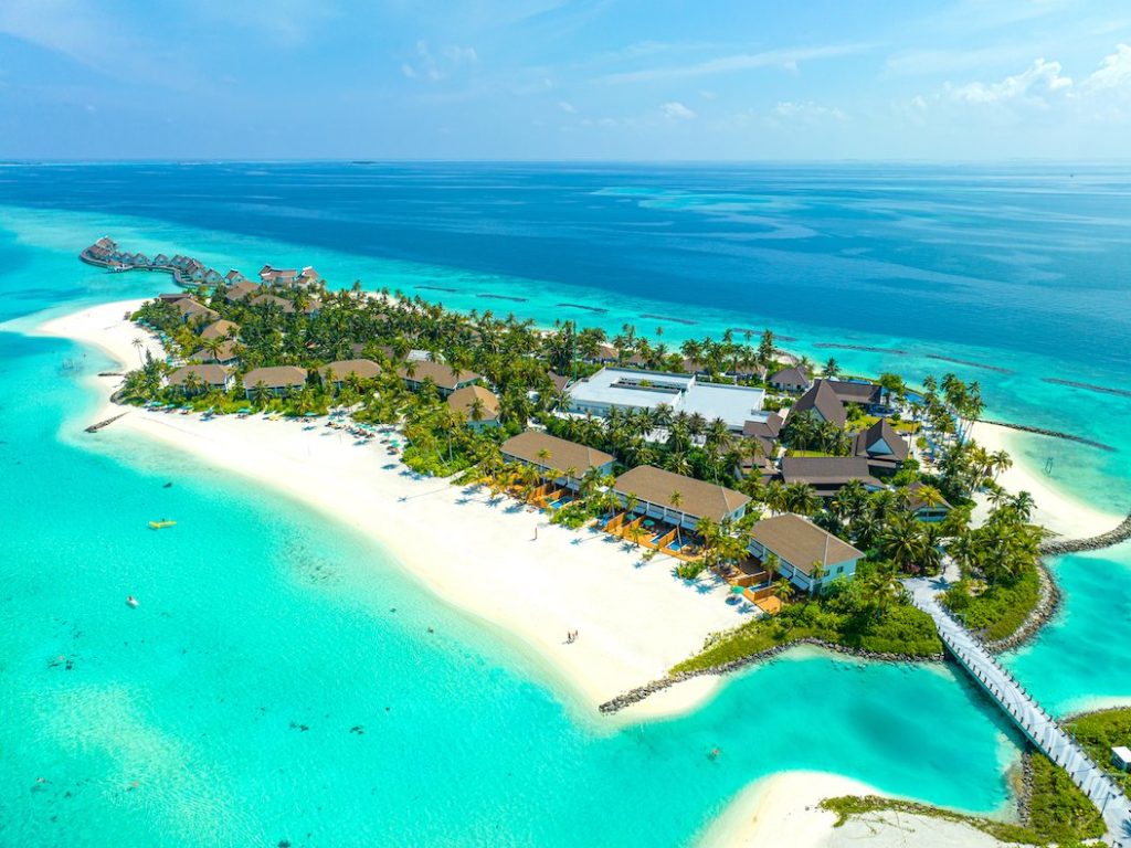 Beach villas at SAii Lagoon Maldives surrounded by crystal-clear ocean and white sandy shores