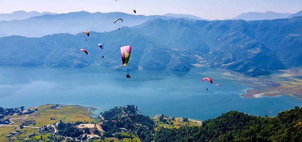 Paraglider soaring over Phewa Lake with the Annapurna mountain range in the background, Pokhara, Nepal
