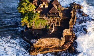 Tanah Lot Temple perched on a rocky outcrop surrounded by ocean waves in Bali