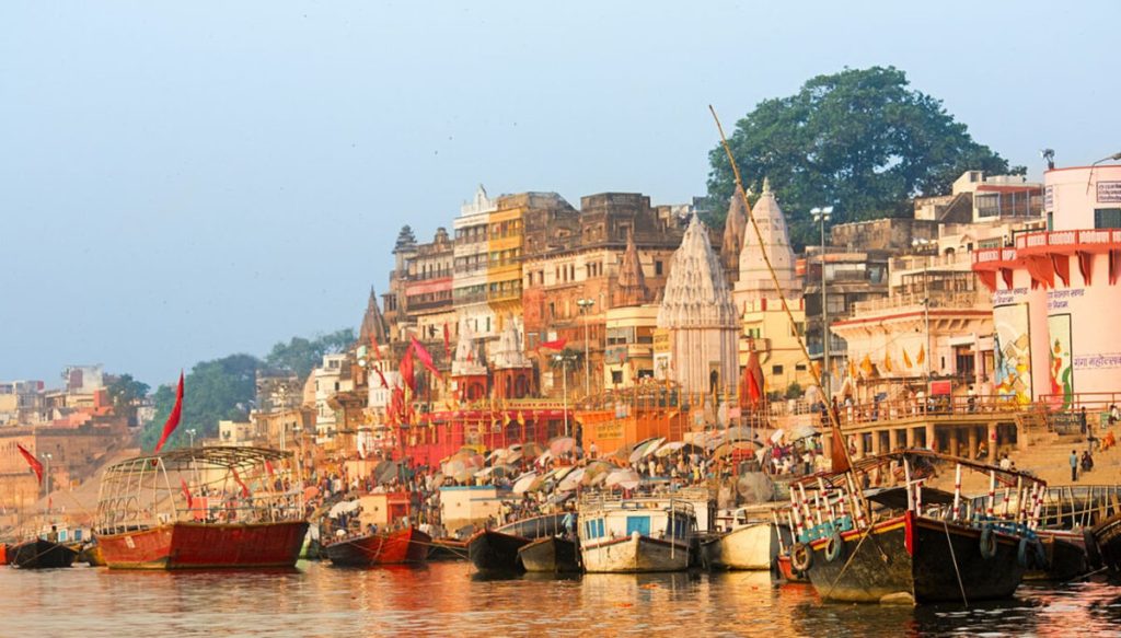 Afternoon view of Varanasi ghats from the Ganges River with historic temples and peaceful riverside ambiance