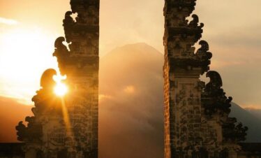 Sunset view from Lempuyang Temple in Bali with vibrant orange and pink skies over mountains