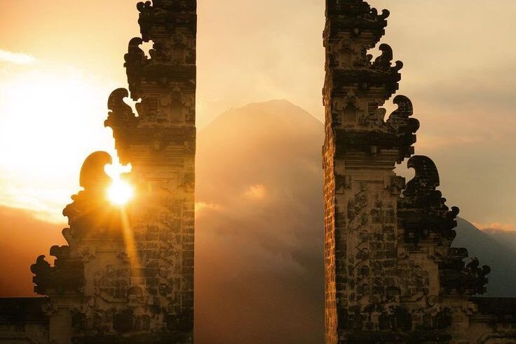Sunset view from Lempuyang Temple in Bali with vibrant orange and pink skies over mountains