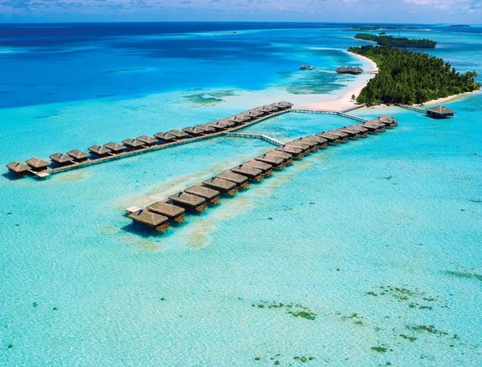 Aerial view of luxurious water villas in the Maldives over turquoise ocean