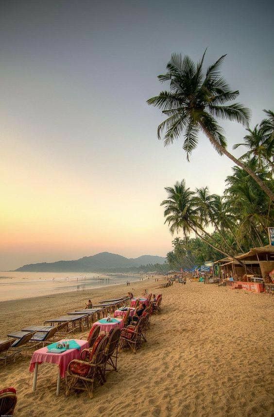 Romantic beachside dining setup on the sandy shores of Goa during sunset