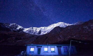 Starry night sky over Naa Gaun village with silhouetted mountains in Nepal