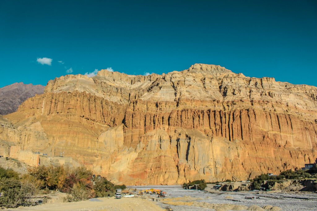 Arid hills and rugged terrain in the Mustang region of Nepal under clear skies
